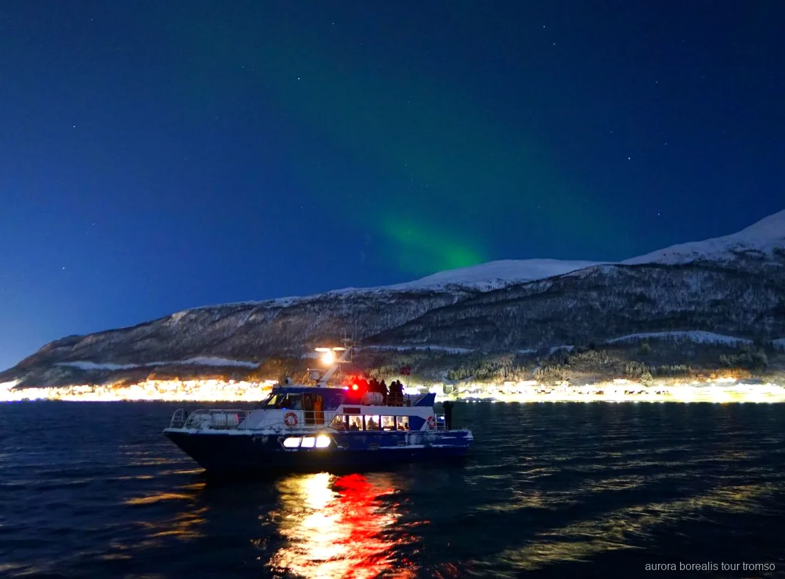 Membro dell'equipaggio che aiuta un ospite con le impostazioni della fotocamera sulla crociera di Tromsø