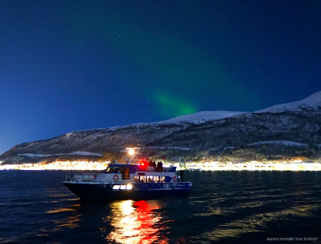 Membre d'équipage aidant un passager à régler son appareil photo sur la croisière de Tromsø