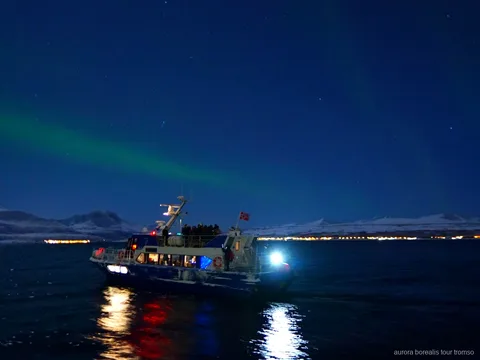 Boot der Tromsø Nordlichter-Abendkreuzfahrt beim Ablegen vom Stadtkai
