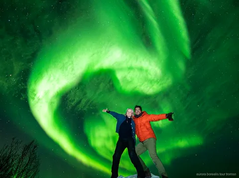 Grupo del tour familiar observando la aurora boreal cerca de Tromsø